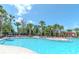 A refreshing community pool surrounded by lush palm trees and comfortable lounge chairs for relaxation at 7019 Wiseman Run Dr, Sun City Center, FL 33573