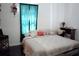Inviting bedroom with a comfortable bed, soft lighting, and a charming desk and chair at 7040 Lumberton Rd, Zephyrhills, FL 33540