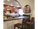 Cozy kitchen featuring wood cabinets, an arched ceiling, and a breakfast bar with seating for casual dining at 7040 Lumberton Rd, Zephyrhills, FL 33540