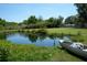 Scenic view of a serene pond near a Mad River Canoe and lush landscaping at 7040 Lumberton Rd, Zephyrhills, FL 33540