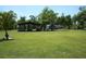 Wide-angle view with a home, storage facility, and tropical landscaping at 7040 Lumberton Rd, Zephyrhills, FL 33540