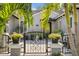 Charming home exterior with a gated entrance, lush landscaping, and a welcoming front porch at 720 Brightwaters Ne Blvd, St Petersburg, FL 33704