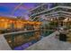 Inviting screened-in pool area with travertine tile, string lights, and comfortable lounge seating at 720 Brightwaters Ne Blvd, St Petersburg, FL 33704
