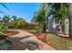 Serene backyard with brick walkway, mature trees, and unique shed at 7909 Garden N Dr, St Petersburg, FL 33710