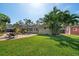 Spacious backyard with lush lawn, patio area, and colorful shed in the background at 7909 Garden N Dr, St Petersburg, FL 33710
