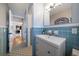 Bright bathroom with a modern sink and vanity, blue tiling, and tiled mosaic floor at 7909 Garden N Dr, St Petersburg, FL 33710