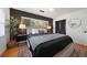 Comfortable bedroom featuring a plush bed, dark accent wall, and natural light from the window at 7909 Garden N Dr, St Petersburg, FL 33710