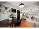 Cozy dining area featuring a round wooden table, modern light fixture, and open access to the living room at 7909 Garden N Dr, St Petersburg, FL 33710