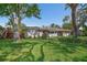 Charming single-story home with a lush green lawn and mature trees offering shade at 7909 Garden N Dr, St Petersburg, FL 33710