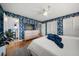 Bright main bedroom featuring blue wallpaper, white bedding, and an ensuite bathroom at 7909 Garden N Dr, St Petersburg, FL 33710