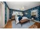 Inviting main bedroom with blue floral wallpaper, white bedding, and a plush area rug at 7909 Garden N Dr, St Petersburg, FL 33710