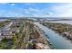 Panoramic aerial view captures waterfront residences, a winding canal, and clear ocean waters under a partly cloudy sky at 830 Pinellas Bayway S, St Petersburg, FL 33715