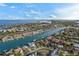 Coastal aerial view features waterfront homes, a canal with boats, and stunning ocean views against a blue skyline at 830 Pinellas Bayway S, St Petersburg, FL 33715