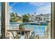 View from balcony with outdoor table and chairs, overlooking a picturesque waterfront and tropical landscaping at 830 Pinellas Bayway S, St Petersburg, FL 33715