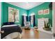 Brightly colored bedroom with stylish decorations, dark curtains, and neutral wood flooring at 830 Pinellas Bayway S, St Petersburg, FL 33715