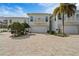 Elegant two-story home featuring a well-manicured lawn and a spacious brick driveway leading to a two-car garage at 830 Pinellas Bayway S, St Petersburg, FL 33715