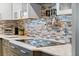 Close-up of a modern kitchen with sleek countertops, a stylish backsplash, and stainless steel utensil rack at 830 Pinellas Bayway S, St Petersburg, FL 33715