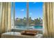 An interior view, highlighting the serene waterfront view, framed by elegant curtains and a comfortable bench at 830 Pinellas Bayway S, St Petersburg, FL 33715