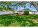 Charming home features a lush, green backyard with mature trees and a white fence at 940 43Rd Ne Ave, St Petersburg, FL 33703