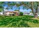 Expansive backyard with lush green lawn, patio area, mature trees, and a charming single-story home in the background at 940 43Rd Ne Ave, St Petersburg, FL 33703