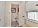 Bright half-bathroom featuring a patterned floor, wainscotting, and a window with natural light at 940 43Rd Ne Ave, St Petersburg, FL 33703