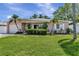 Charming single-story home featuring a well-manicured lawn, tidy landscaping, and lovely curb appeal enhanced by palm trees at 940 43Rd Ne Ave, St Petersburg, FL 33703