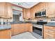 Traditional kitchen featuring wood cabinetry, stainless steel appliances, and gray countertops at 940 43Rd Ne Ave, St Petersburg, FL 33703