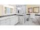 Modern bathroom boasts marble countertops, sleek white cabinets, and a glass-enclosed shower, showcasing elegant design elements at 9897 Sago Point Dr, Seminole, FL 33777