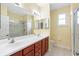 Bright bathroom features a double sink vanity and glass-door shower at 9897 Sago Point Dr, Seminole, FL 33777