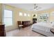 Sunlit bedroom with hardwood floors, features a ceiling fan, and access to a screened patio, offering tranquil views at 9897 Sago Point Dr, Seminole, FL 33777