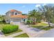 Two-story home featuring a red tile roof, two-car garage, and a landscaped front yard with mature trees at 9897 Sago Point Dr, Seminole, FL 33777