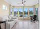 Bright living room featuring large windows with lake views and light wood floors at 9897 Sago Point Dr, Seminole, FL 33777