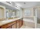 Spacious bathroom with double sinks, soaking tub, and walk-in shower at 10524 White Peacock Pl, Riverview, FL 33578