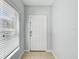 Bright entryway featuring a white front door, window with blinds, and neutral tile flooring at 10524 White Peacock Pl, Riverview, FL 33578