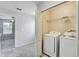 Bright laundry room with modern washer and dryer, and convenient shelving at 10524 White Peacock Pl, Riverview, FL 33578