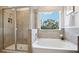 Beautiful bathroom with a soaking tub and separate glass shower with light brown tiling at 10589 Farm Hill Ave, Land O Lakes, FL 34638