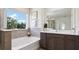 Modern bathroom with a soaking tub, single vanity, gray accents, and a large window at 10589 Farm Hill Ave, Land O Lakes, FL 34638