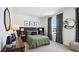 Comfortable bedroom with a queen bed, soft carpet, a decorative mirror, and natural light from the window at 10589 Farm Hill Ave, Land O Lakes, FL 34638