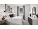 Modern bedroom featuring a cozy bed, stylish lamps, trendy wall art, and a dresser with clean lines at 10589 Farm Hill Ave, Land O Lakes, FL 34638