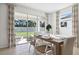 Elegant dining room with a wooden table, stylish chairs, large windows overlooking the backyard, and tasteful decor at 10589 Farm Hill Ave, Land O Lakes, FL 34638