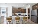 Modern kitchen featuring a large island with seating, stainless steel appliances, and elegant dark wood cabinetry at 10589 Farm Hill Ave, Land O Lakes, FL 34638