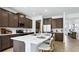 Open-concept kitchen with a large island, stainless steel appliances, dark cabinets, and seamless access to other living areas at 10589 Farm Hill Ave, Land O Lakes, FL 34638