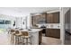 Bright, contemporary kitchen boasting a spacious island, modern appliances, dark cabinets, and an adjacent dining area at 10589 Farm Hill Ave, Land O Lakes, FL 34638