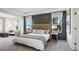 Spacious primary bedroom featuring modern decor, tray ceilings and lots of natural light at 10589 Farm Hill Ave, Land O Lakes, FL 34638