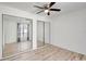 Bedroom featuring wood floors, large mirror closet, a ceiling fan, and a window for natural light at 107 Parkside Colony Dr, Tarpon Springs, FL 34689