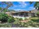 Landscaped yard showcasing the back of the home with a screened porch and patio area at 107 Parkside Colony Dr, Tarpon Springs, FL 34689