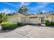 Inviting home exterior featuring a one car garage, quaint courtyard and well-maintained landscaping at 107 Parkside Colony Dr, Tarpon Springs, FL 34689
