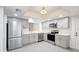 Renovated kitchen with stainless appliances, gray cabinets, and modern lighting fixtures at 107 Parkside Colony Dr, Tarpon Springs, FL 34689