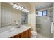 Well-lit bathroom featuring a double vanity, large mirror, and glass-enclosed shower with tile surround at 109 Wateredge Ct, Safety Harbor, FL 34695