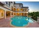 Backyard pool and spacious patio with multi-story house featuring balconies and spiral staircase in the background at 109 Wateredge Ct, Safety Harbor, FL 34695